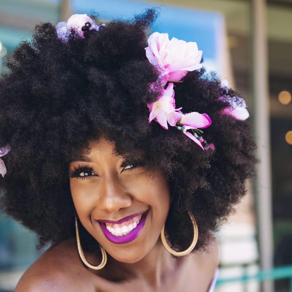 Girl with moisturized natural afro with flowers